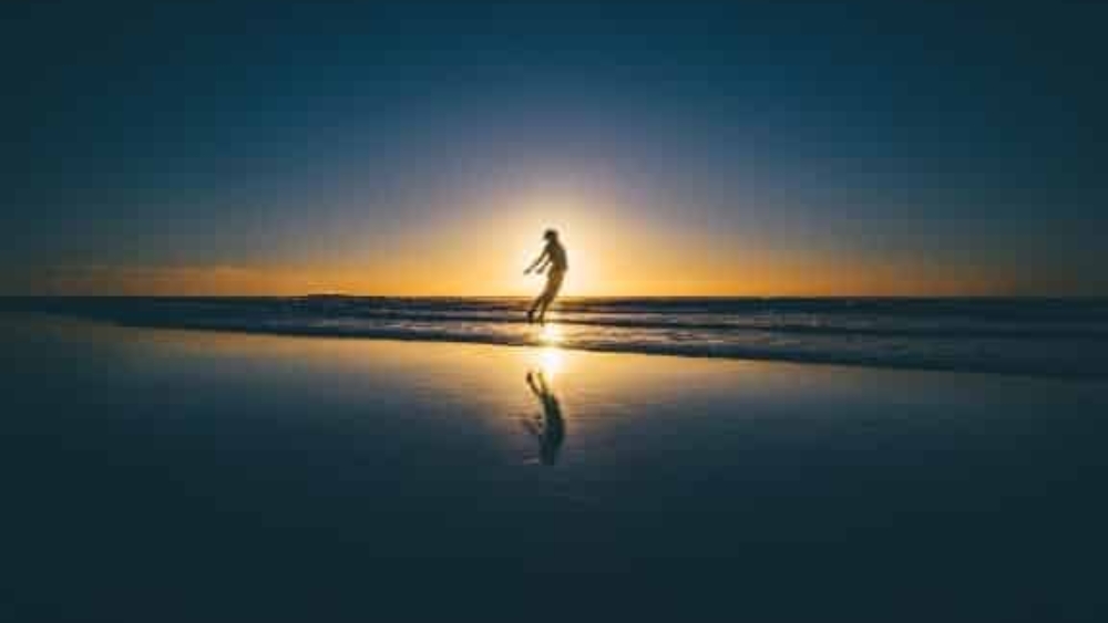 oscar-ivan-larach-zablah-honduras-mujer-en-la-playa-brincando-en-atardecer-oscarlarch-com